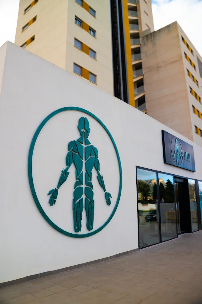 Fachada de la clínica Salufit en Calpe, con el símbolo en la pared y el Peñón reflejado